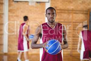 Confident  basketball player holding a basketball