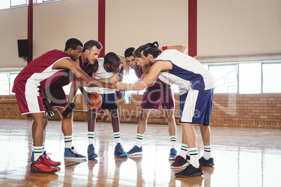 Basketball players forming a handstack in the court