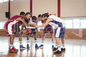 Basketball players forming a handstack in the court