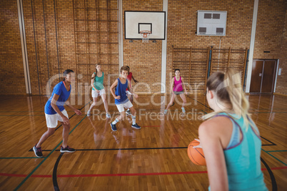 High school kids playing basketball in the court