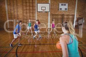 High school kids playing basketball in the court