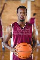 Confident basketball player holding a basketball