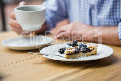 Mid-section of senior man holding a coffee cup