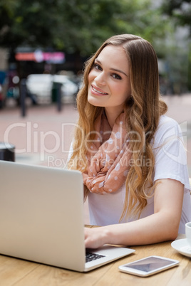 Woman using digital laptop while sitting at table