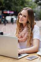 Woman using digital laptop while sitting at table