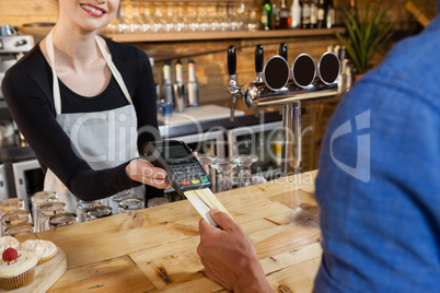 Man making payment on credit card reader machine