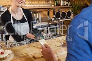 Man making payment on credit card reader machine