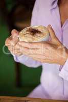 Cropped image of senior woman holding coffee cup