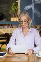 Senior woman using tabletv while sitting at table