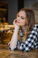 Thoughtful young woman sitting at table