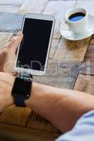 High angle view  of woman holding mobile phone at table