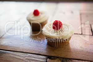 Close up of raspberry cupcakes on wooden table