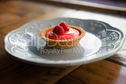 Close up of raspberry tart served in plate on table