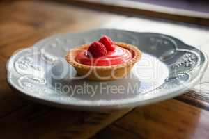 Close up of raspberry tart served in plate on table