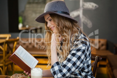 Side view of young woman reading book