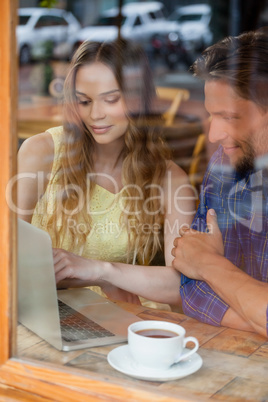 Happy couple using digital laptop