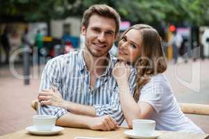 Portrait of happy couple sitting at sidewalk cafe