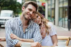 Portrait of romantic couple sitting at sidewalk cafe