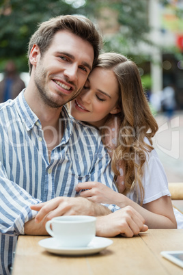 Happy romantic couple sitting at sidewalk cafe