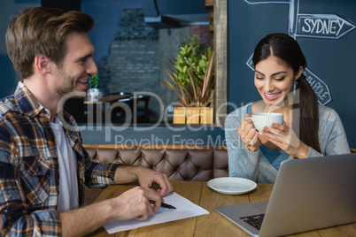 Young couple interacting while having coffee