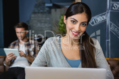 Portrait of young woman using laptop