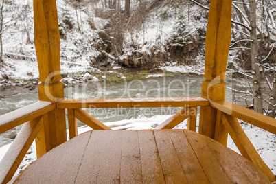 Snow covered wooden arbor .