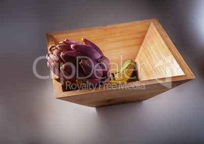 Fresh Artichoke in a square wooden plate.