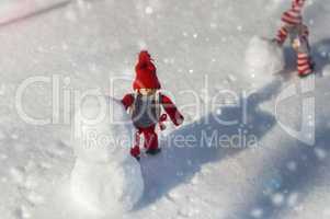 Two wooden dolls on white snow