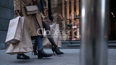 Young women walking with bags after shopping
