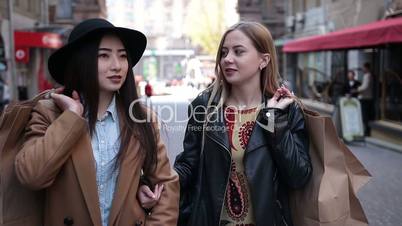 Multiracial female shoppers holding shopping bags