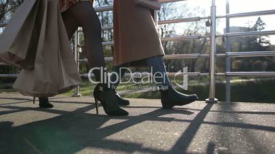 Side view of females legs walking on bridge