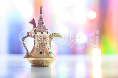 Silver Arabic Coffee pot in colorful illuminated background.