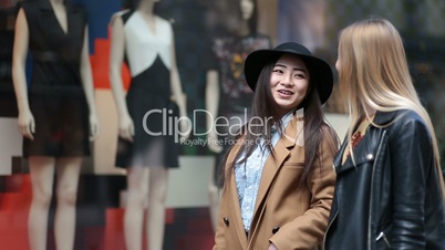 Shopping women looking at clothing store window