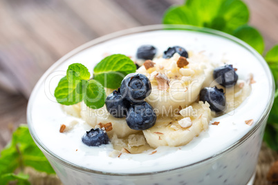 Yogurt with fresh blueberry, banana and almond nuts, delicious dessert for healthy breakfast