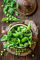 Fresh green peas on dark wooden rustic background