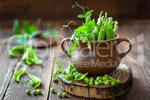 Fresh green peas on dark wooden rustic background