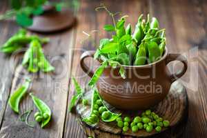 Fresh green peas on dark wooden rustic background