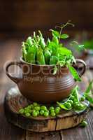 Fresh green peas on dark wooden rustic background