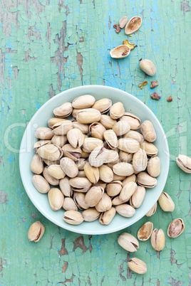 Pistachio nuts on wooden background, top view