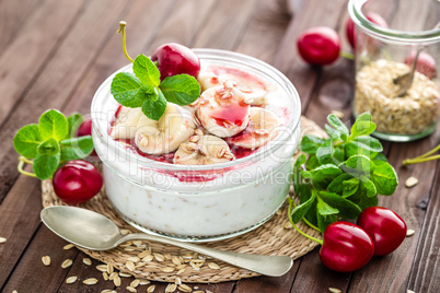 Fresh yogurt with cherry, banana and oats, delicious dessert for healthy breakfast