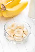 Fresh sliced bananas on white wooden background closeup, healthy eating