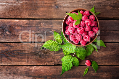 Fresh raspberry with leaves on wooden background