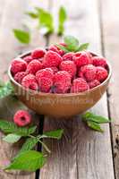 Fresh raspberry with leaves on wooden background