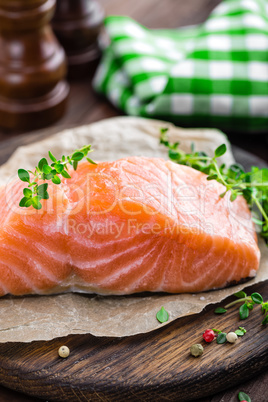 Raw salmon fish fillet on wooden board closeup