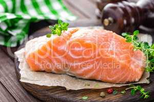 Raw salmon fish fillet on wooden board closeup