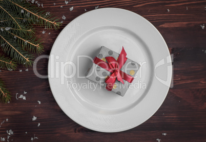 White plate with a gift wrapped, top view