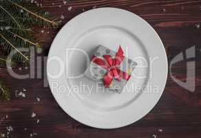 White plate with a gift wrapped, top view