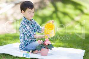 Mixed Race Young Boy Watering His Potted Flowers Outside On The