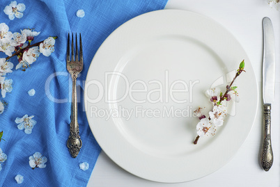 Empty white ceramic plate with iron vintage cutlery