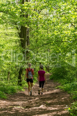 Two young girl walking in the forest